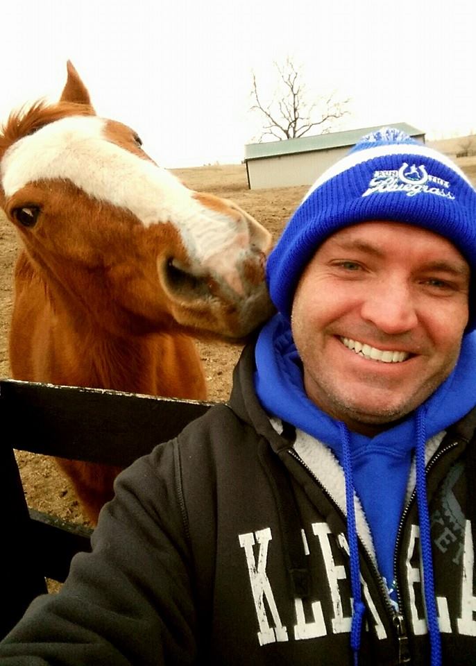 During a recent training run, RunTheBluegrass Race Director Eric Patrick Marr gets a smooch from one of the spectators, Jonathan, who lives on Ballantrae Farm along mile seven. (Photo provided)