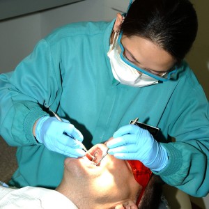 050427-N-9693B-004 Manama, Bahrain (April 27, 2005) - Dental Hygienist Liza Siwa conducts a routine cleaning for Senior Chief Quarter Master Karl Darr in the Naval Branch Health Clinic at Naval Support Activity (NSA) Bahrain. The clinic, which provides dental treatment for Sailors stationed throughout the 5th Fleet Area of Responsibility, is scheduled to open an edition of seven new treatment rooms in September 2005. U.S. Navy photo (RELEASED)