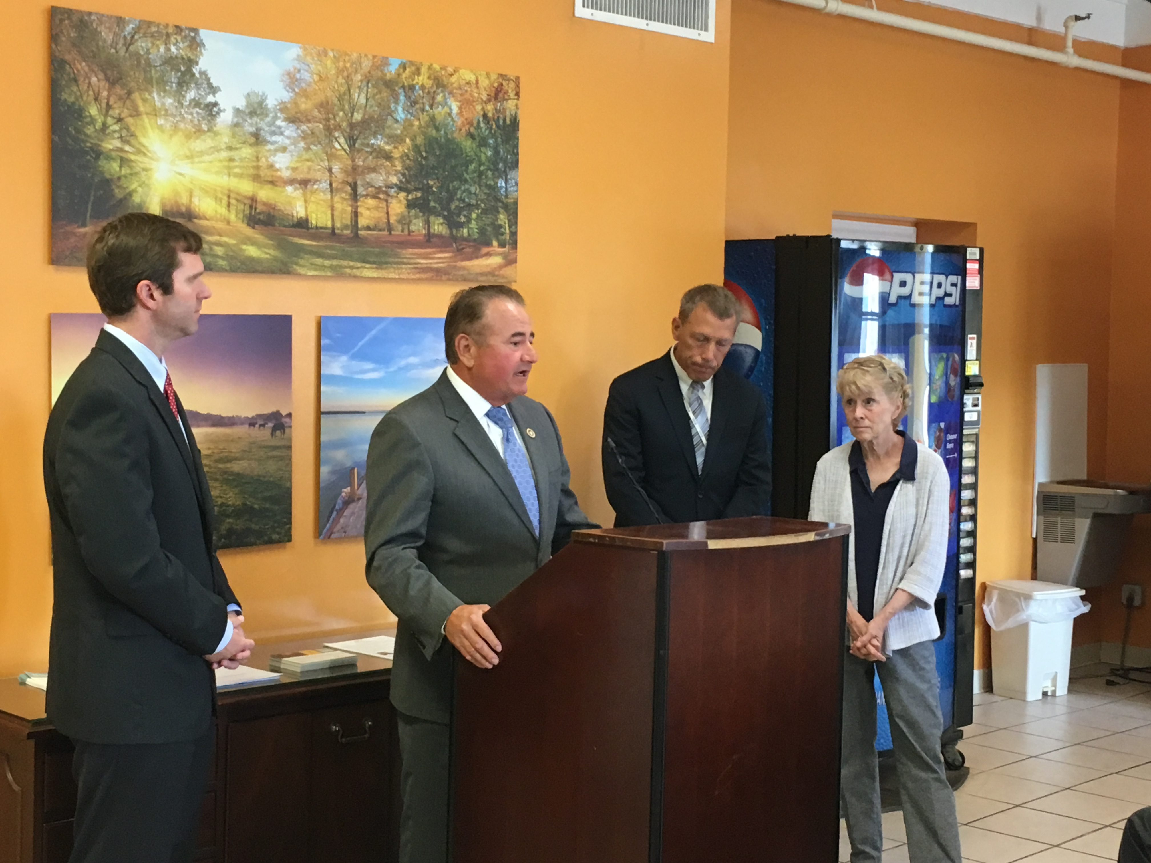 State Rep. Dennis Keene R-Wilder talks about efforts to get funding for heroin treatment in Northern Kentucky. Left to right, Attorney GEneral Andy Beshear, KEene, Jim Beiting of Transitions and Covington Mayor Sherry Carran.