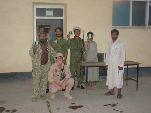 With the Northern Alliance, in Bagram Air Base, Afghanistan. The Afghanis are holding up squadron stickers McGrath gave them. She showed them this picture on here digital camera after it was taken. They had never seen anything like it before.